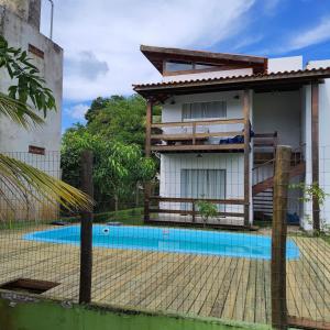 una casa con piscina frente a ella en Dalas Village, en Maraú