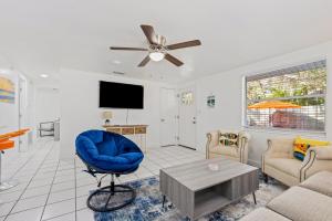 a living room with a blue chair and a tv at Casa Cocoanut in Sarasota