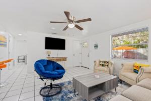 sala de estar con silla azul y TV en Casa Cocoanut, en Sarasota