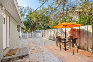 una mesa con una sombrilla naranja en el patio en Casa Cocoanut, en Sarasota