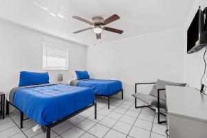 Una habitación con dos camas y un ventilador de techo. en Casa Cocoanut, en Sarasota