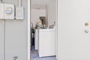 una pequeña nevera blanca en una cocina junto a una puerta en Casa Cocoanut, en Sarasota 16 fotos más