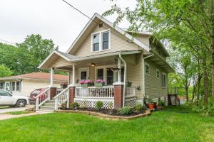a house with a porch with flowers on it at Cheerful 3 BR. 2 Bath, Spacious Family Home in Akron