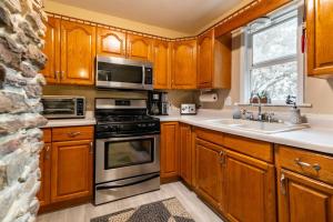 una cocina con armarios de madera y electrodomésticos de acero inoxidable en Cheerful 3 BR. 2 Bath, Spacious Family Home en Akron