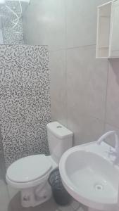 クリチバにあるPousada Félixのバスルーム(白いトイレ、シンク付)