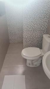 a white bathroom with a toilet and a sink at Pousada Félix in Curitiba