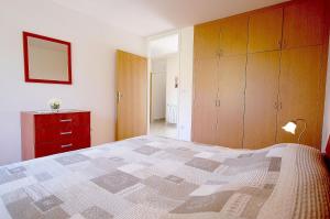 een slaapkamer met een bed en een rode dressoir bij Family friendly apartments with a swimming pool , Krk - 20500 in Malinska