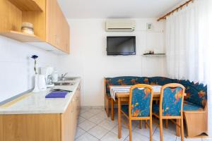 eine Küche mit einem Tisch, Stühlen und einem Sofa in der Unterkunft Apartments with a parking space Njivice, Krk - 20504 in Njivice