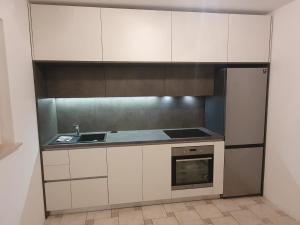 La cuisine est équipée de placards blancs, d'un évier et d'une cuisinière. dans l'établissement Apartments by the sea Njivice, Krk - 20519, à Njivice