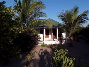 una sombra de una persona parada frente a una casa en Kinkiliba Beach Lodge, en Sanyang