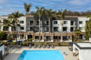 an aerial view of a hotel with a pool and palm trees at Courtyard by Marriott San Diego Carlsbad in Carlsbad