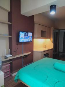 Habitación con cama y TV de pantalla plana. en Room Apartemen by GIANDARA, en Sayang