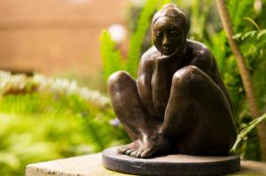 une statue en bronze d'une femme assise sur un rocher dans l'établissement Suite 1-A Monasterio Garden House Welcome to San Angel, à Mexico