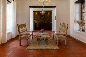 a living room with a table and chairs and a chandelier at La Xalca Hotel - Asociado Casa Andina in Chachapoyas