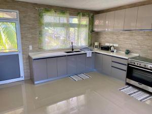 a kitchen with a sink and a stove at Taina - Terrasse - Bord de mer - in Opoa