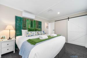 Un pat sau paturi într-o cameră la La Petite Maison - Taupo