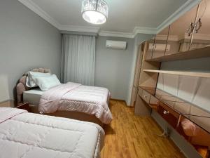 a small room with two beds and a dresser at Duplex in westown beverly hills in Sheikh Zayed