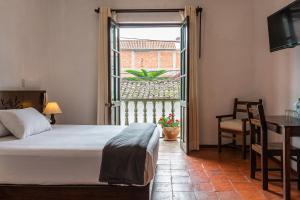 a bedroom with a bed and a table and a window at La Xalca Hotel - Asociado Casa Andina in Chachapoyas