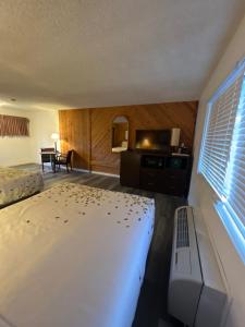 a bedroom with a bed and a kitchen and a table at Cedarwood Inn of Ashland in Ashland