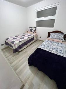 a bedroom with two beds and a mirror in it at Departamento frente al mar YMAS in La Serena
