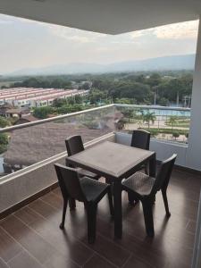 a table and chairs on a balcony with a view at Acogedor Apartamento en Ricaurte con BBQ in Girardot