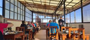 a group of people sitting at tables in a restaurant at Hotel CESARE in Uyuni