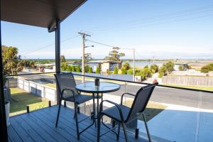 a balcony with a table and chairs and a view of the ocean at Bridport by the Sea in Bridport