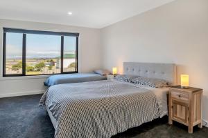 a bedroom with two beds and a large window at Bridport by the Sea in Bridport