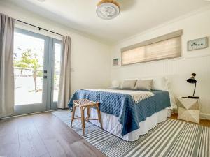 a bedroom with a bed and a table and a window at El Nido Beachlife Cottage in South Bay Los Angeles in Redondo Beach