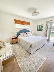 a bedroom with a large bed and a chair at El Nido Beachlife Cottage in South Bay Los Angeles in Redondo Beach