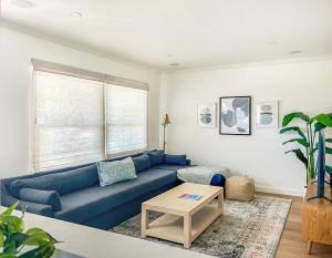 a living room with a blue couch and a table at El Nido Beachlife Cottage in South Bay Los Angeles in Redondo Beach