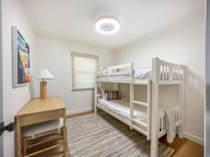 a bedroom with two bunk beds and a desk at El Nido Beachlife Cottage in South Bay Los Angeles in Redondo Beach