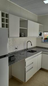 a kitchen with white cabinets and a sink at Complejo de casas en Pueblo Centenario in Santa Isabel