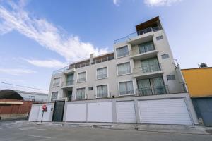 un edificio blanco con puertas blancas de garaje en una calle en LM Hoteles, en Piura