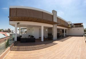 un edificio con un techo grande y una terraza de madera en LM Hoteles, en Piura