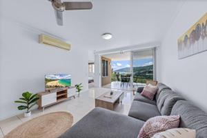 a living room with a couch and a table at Airlie Summit Apartments in Airlie Beach