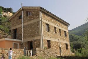 a man standing in front of a brick building at Locanda La Corte in Serramezzana