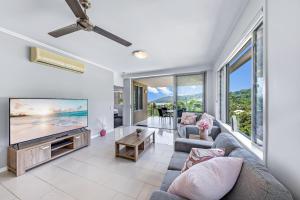a living room with a large flat screen tv at Airlie Summit Apartments in Airlie Beach
