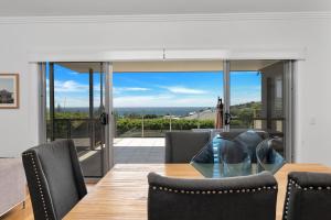 a dining room with a table and a view of the ocean at Sapphire on Wilson Gerringong in Gerringong