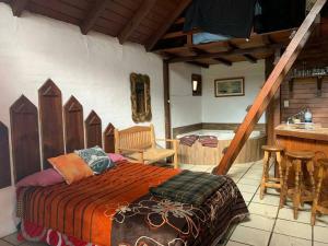 a bedroom with a bed in a room with a bar at Cabaña Romantica Odette en Zona Boscosa con WiFi in Mazamitla