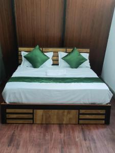 uma cama com almofadas verdes num quarto em Misty Ghats Resort em Wayanad