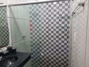 a bathroom with a shower with a sink and a mirror at Olga Moreira 01 - inclui garagem in Paragominas