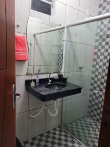 uma casa de banho com um lavatório e um espelho em Olga Moreira 01 - inclui garagem em Paragominas
