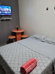 a bedroom with a bed and a table and a tv at Olga Moreira 01 - inclui garagem in Paragominas