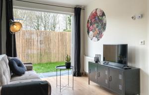 a living room with a couch and a television at 2 Bedroom Lovely Home In Heinkenszand in Heinkensand
