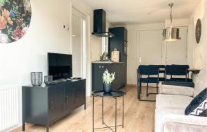 a living room with a couch a table and a tv at 2 Bedroom Lovely Home In Heinkenszand in Heinkensand