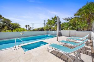a swimming pool with lounge chairs and a swimming poolvisorvisor at Unit 6 Taralla 16 18 Edgar Bennett Avenue Noosa Heads in Noosa Heads