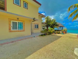 a house on the beach next to the ocean at Huahine Beach House in Fare