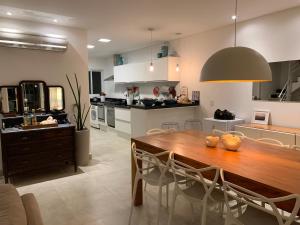 a kitchen and dining room with a wooden table and chairs at Linda Casa em Camburizinho 100 m da praia in São Sebastião +33 photos