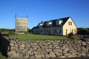 dom za kamienną ścianą i znak w obiekcie Pairc Lodge w mieście Doolin